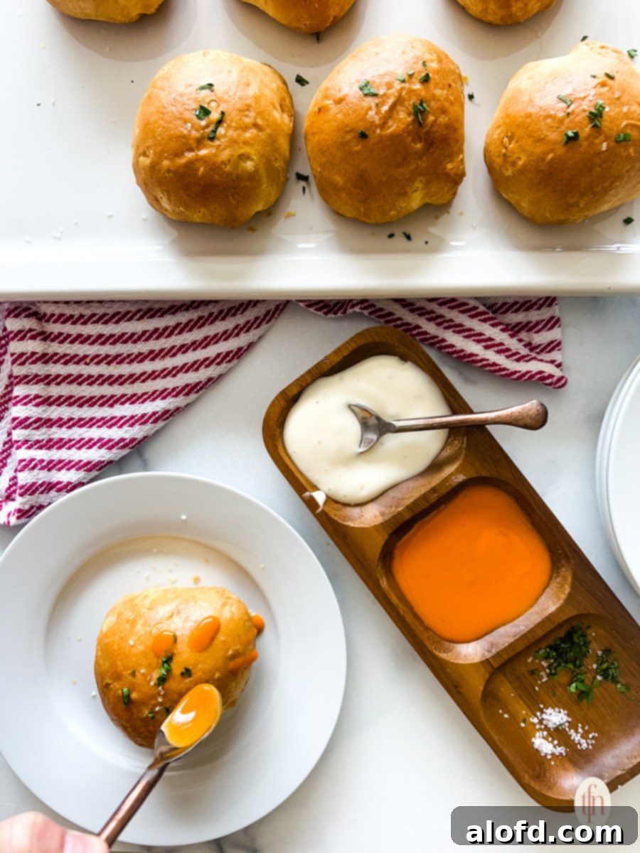 Fiery Buffalo Chicken Poppers 5 A vibrant platter of golden-baked buffalo chicken dip bites arranged neatly, with small dishes of ranch and blue cheese dressing, and celery sticks for dipping.