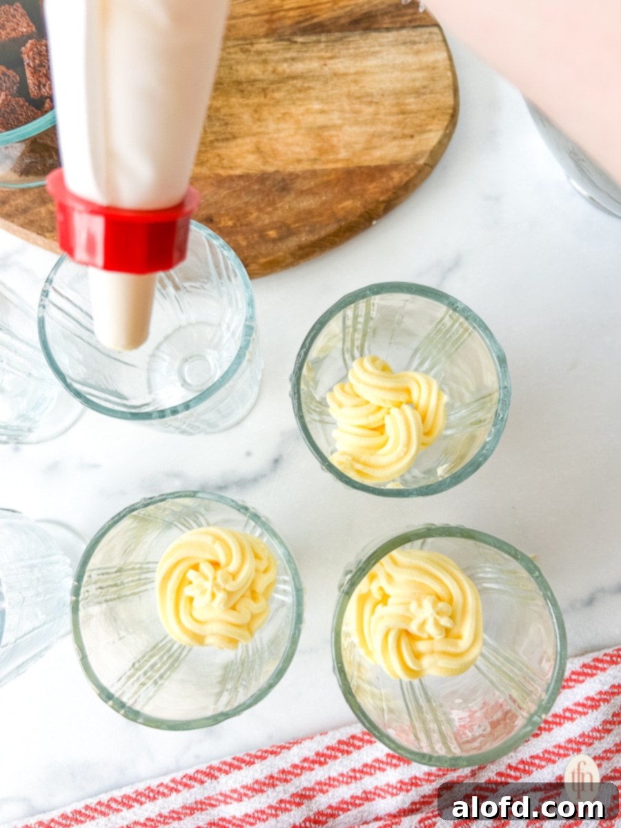 Velvety Vanilla Cloud 7 Piping the mousse into glass bowls.