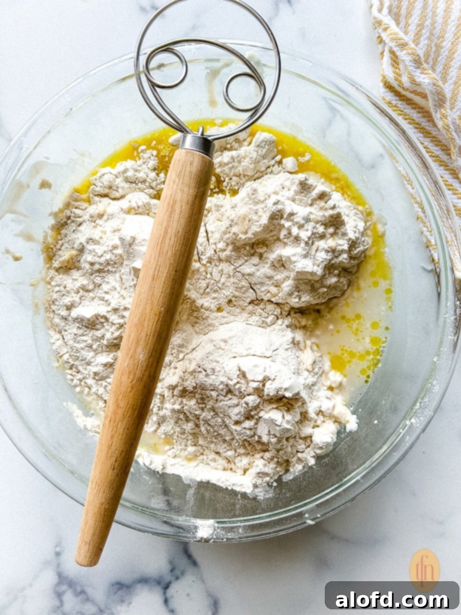 Flour, water, and active sourdough discard combined in a bowl for Sourdough Pizza Crust recipe.