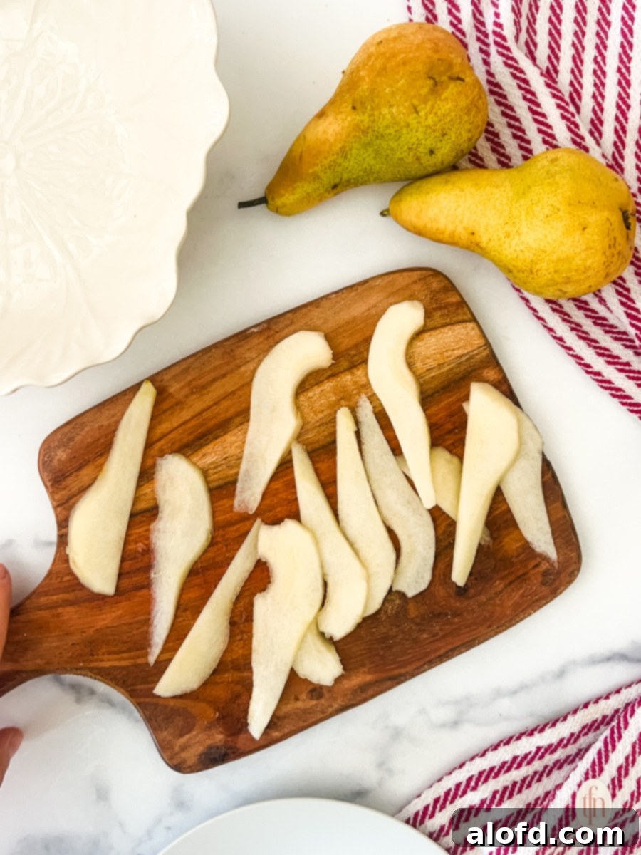 Sliced pears sitting on a cutting board.