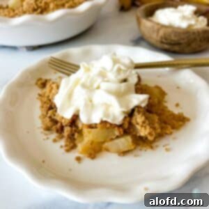 A plated pear dessert topped with whipped cream.