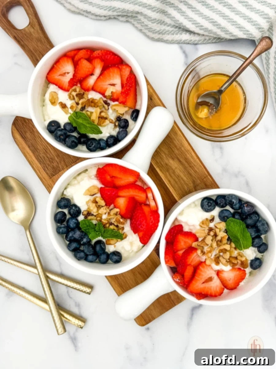 Nourishing Cottage Cheese Creation 2 Three bowls of cottage cheese and fruit on a wooden board with spoon and a glass of honey.