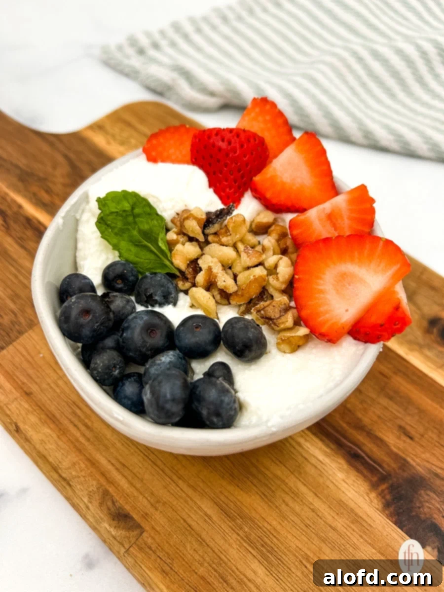 Nourishing Cottage Cheese Creation 3 Cottage cheese and fruit bowl on a wooden board.
