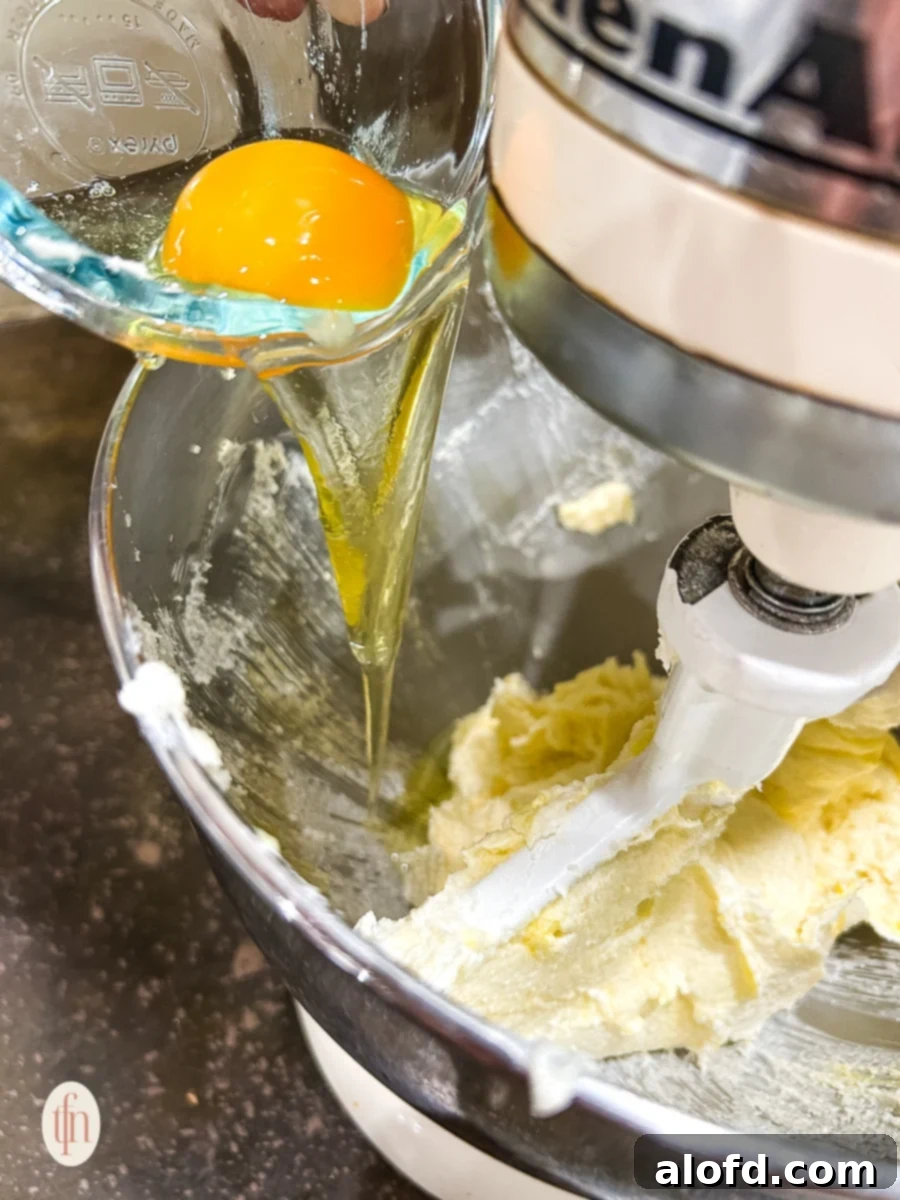 Sweetheart Delights 6 Adding an egg to the creamed butter and sugar mixture in a stand mixer.