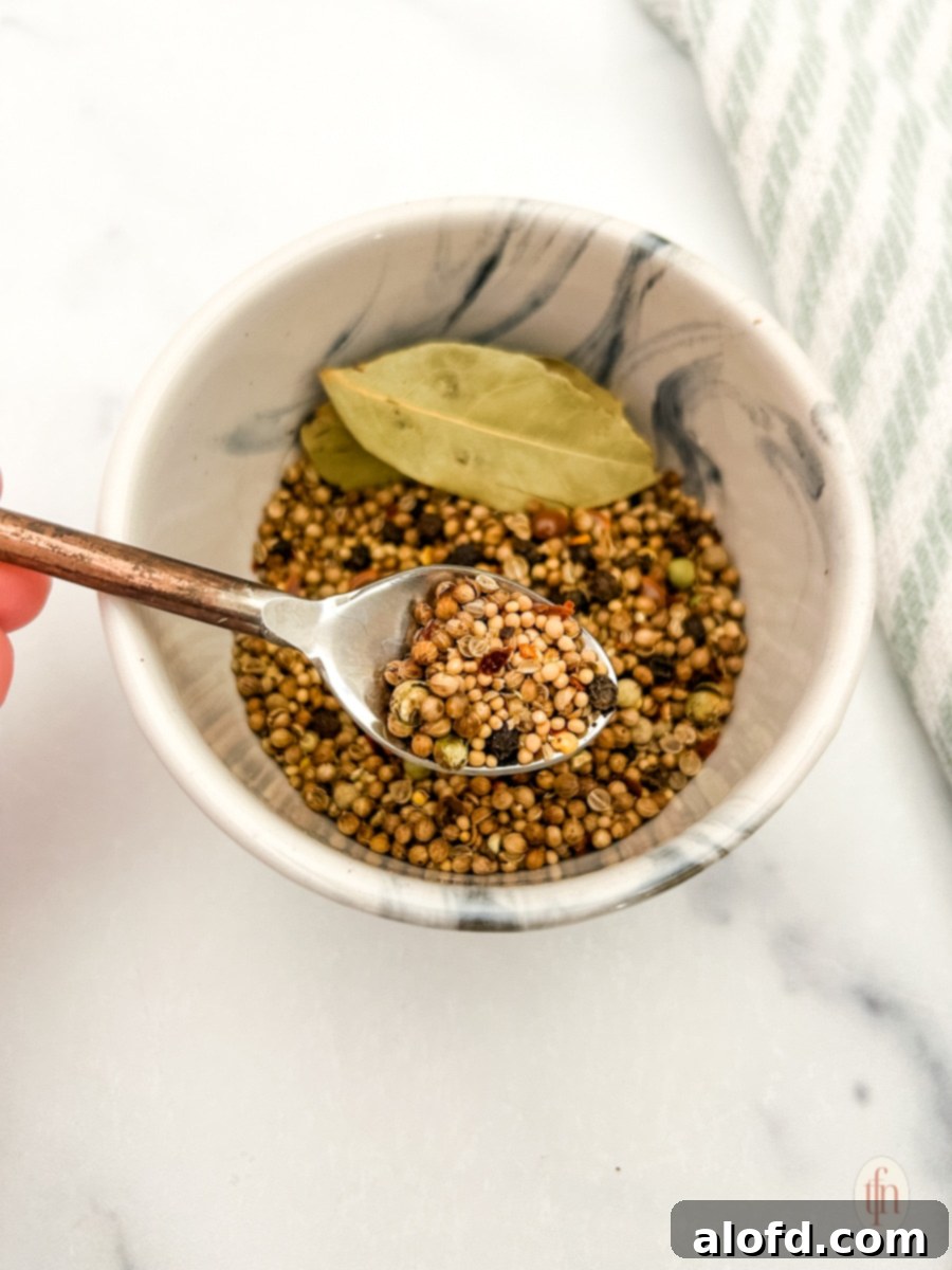 Signature Corned Beef Spice Blend 3 A bowl filled with freshly mixed homemade corned beef seasoning, with a spoon resting inside, highlighting its readiness for use.