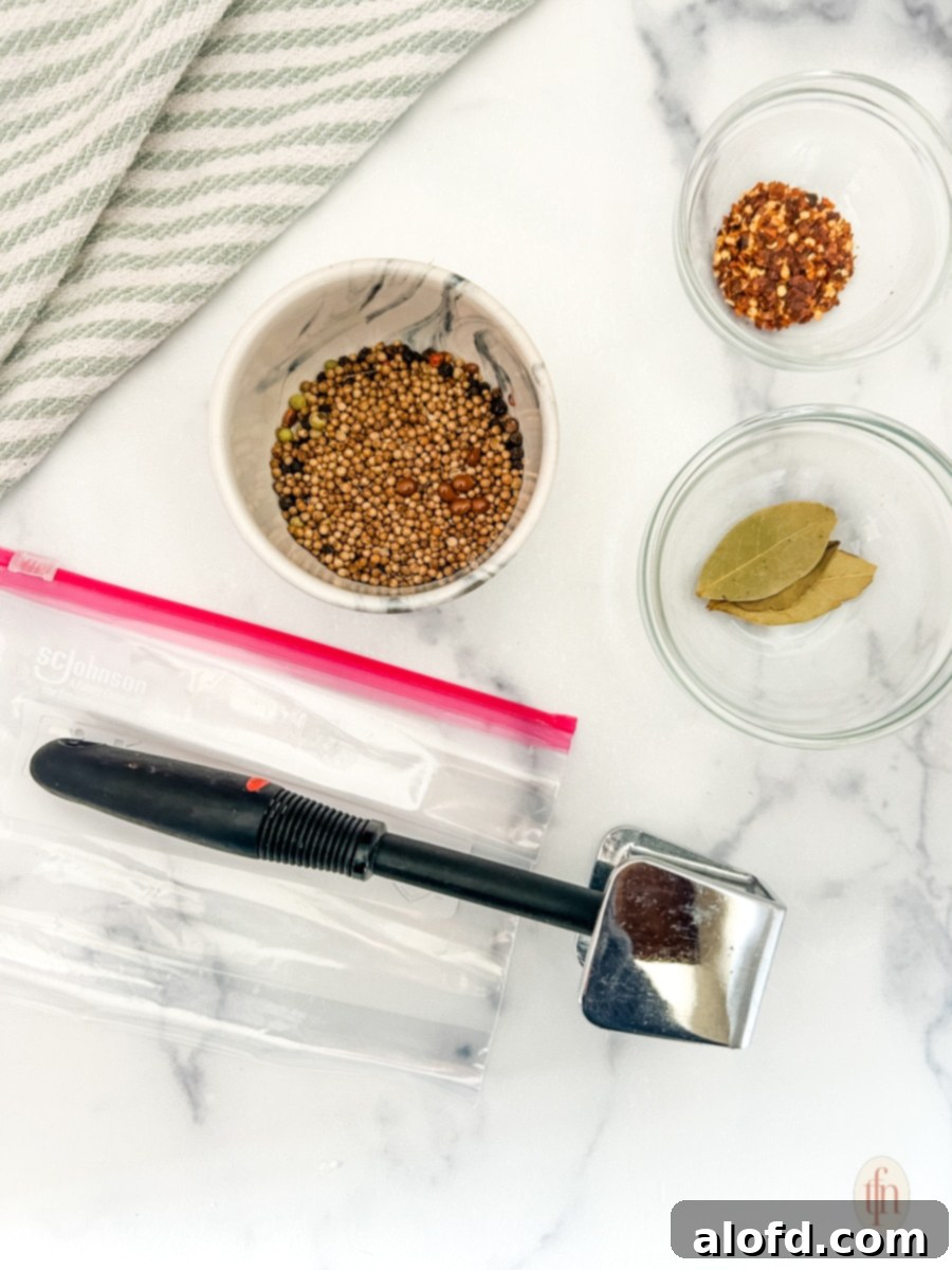 Signature Corned Beef Spice Blend 5 Various kitchen tools and spices laid out on a surface, including a mortar and pestle, measuring spoons, and whole spices, signifying preparation for making homemade seasoning.