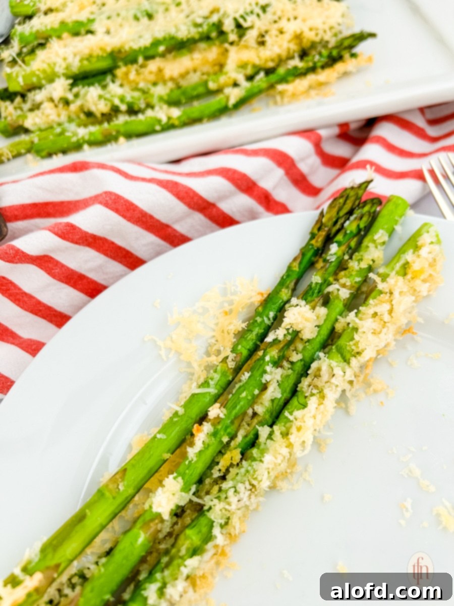Creamy Asparagus Cheese Bake 2 Asparagus casserole on a white plate, showcasing its golden-brown topping and vibrant green spears.