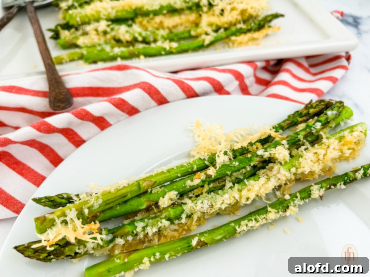 Creamy Asparagus Cheese Bake 10 Parmesan roasted asparagus on a white plate, ready to be served.