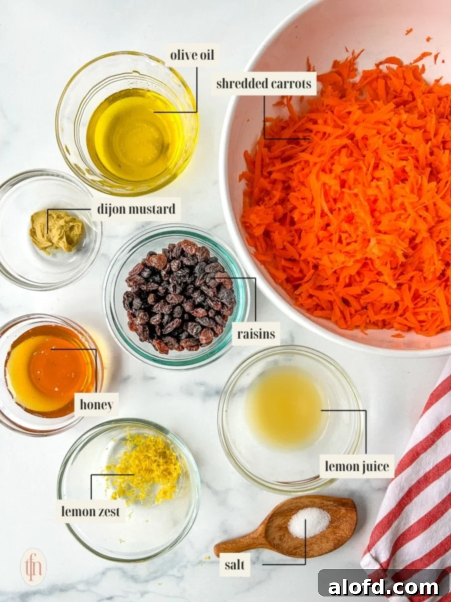 Organized ingredients for shredded carrot salad, including carrots, raisins, and dressing components.