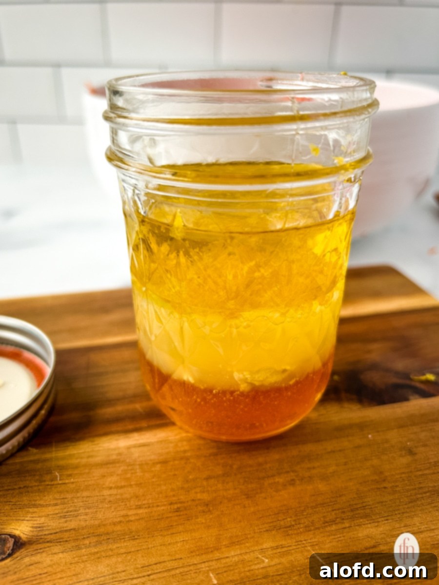 The prepared zesty dressing in a glass jar, ready to be poured.