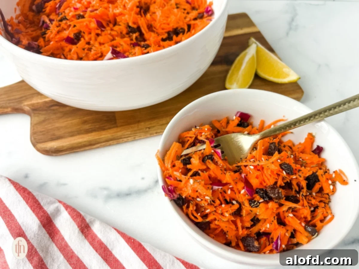 A wide shot of shredded carrot salad in a bowl with a fork, ready for serving.