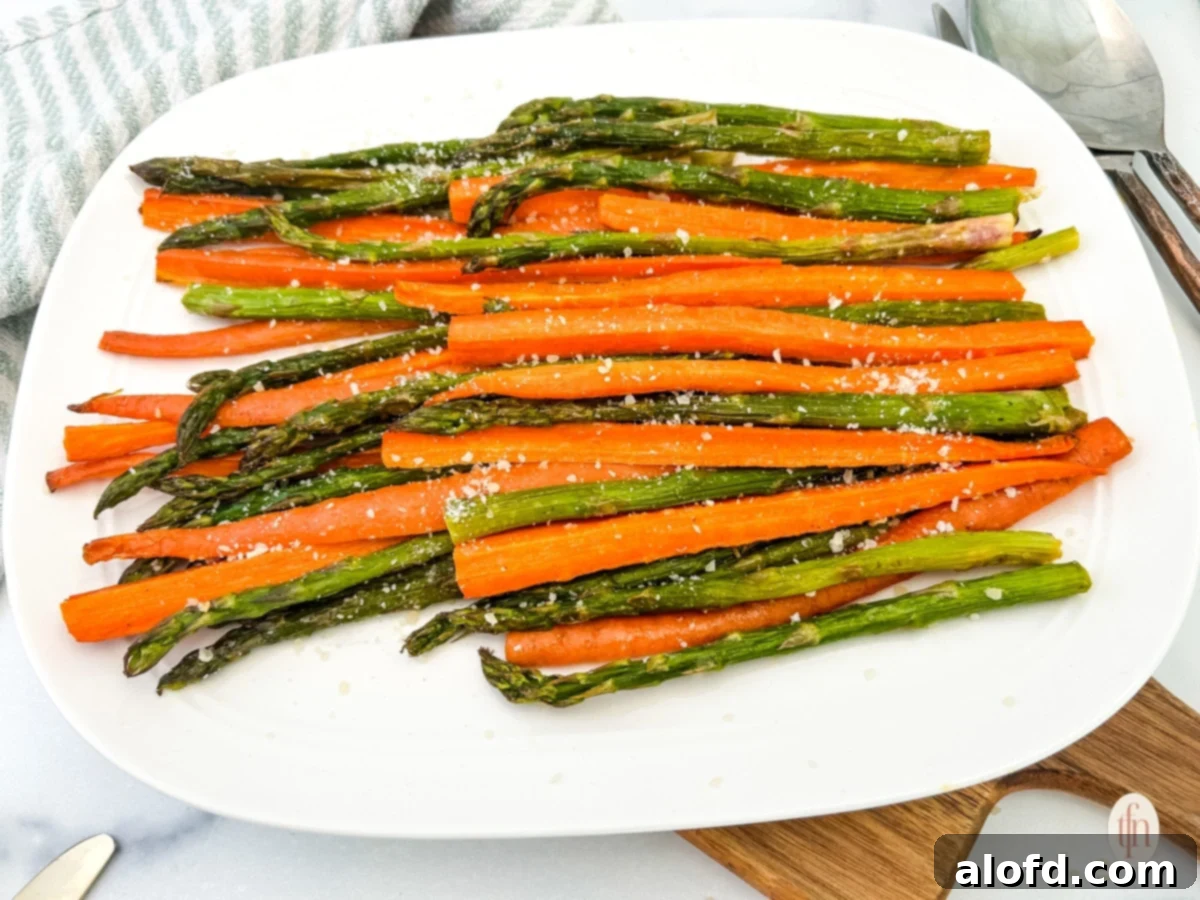 Golden Roasted Carrots and Asparagus 9 A full plate of vibrant roasted carrots and asparagus positioned on a wooden board, ready to be enjoyed as a wholesome meal.