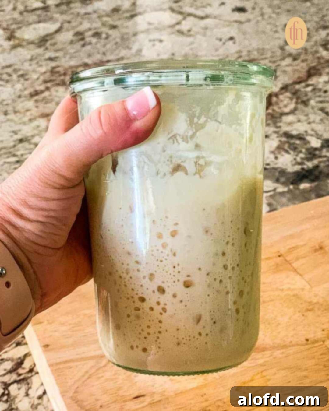 Banish Sourdough Starter Blues 11 Sourdough starter on a Weck jar, grabbed in one hand.