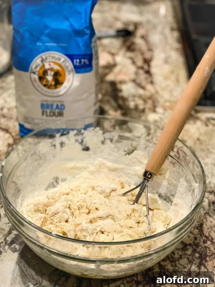 Banish Sourdough Starter Blues 8 Whisking bread flour with warm water and sugar in a mixing bowl.
