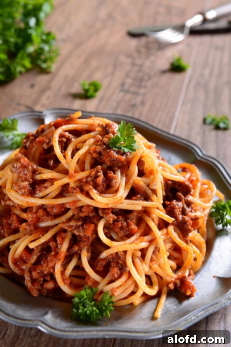 A plate of perfectly cooked spaghetti garnished with fresh parsley.