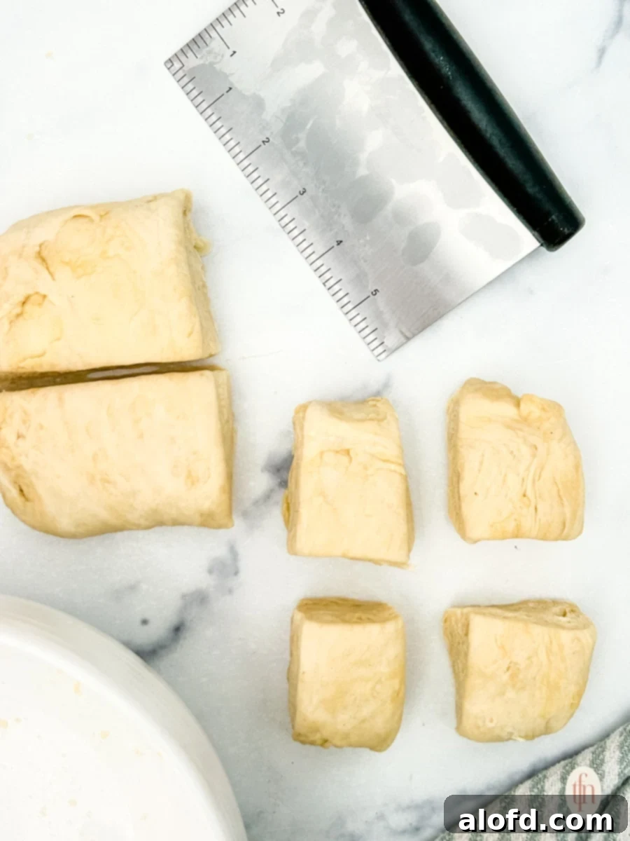 Artisan Sourdough Flatbread 6 Sliced sourdough flatbread dough on a counter with a dough cutter, ready for rolling.
