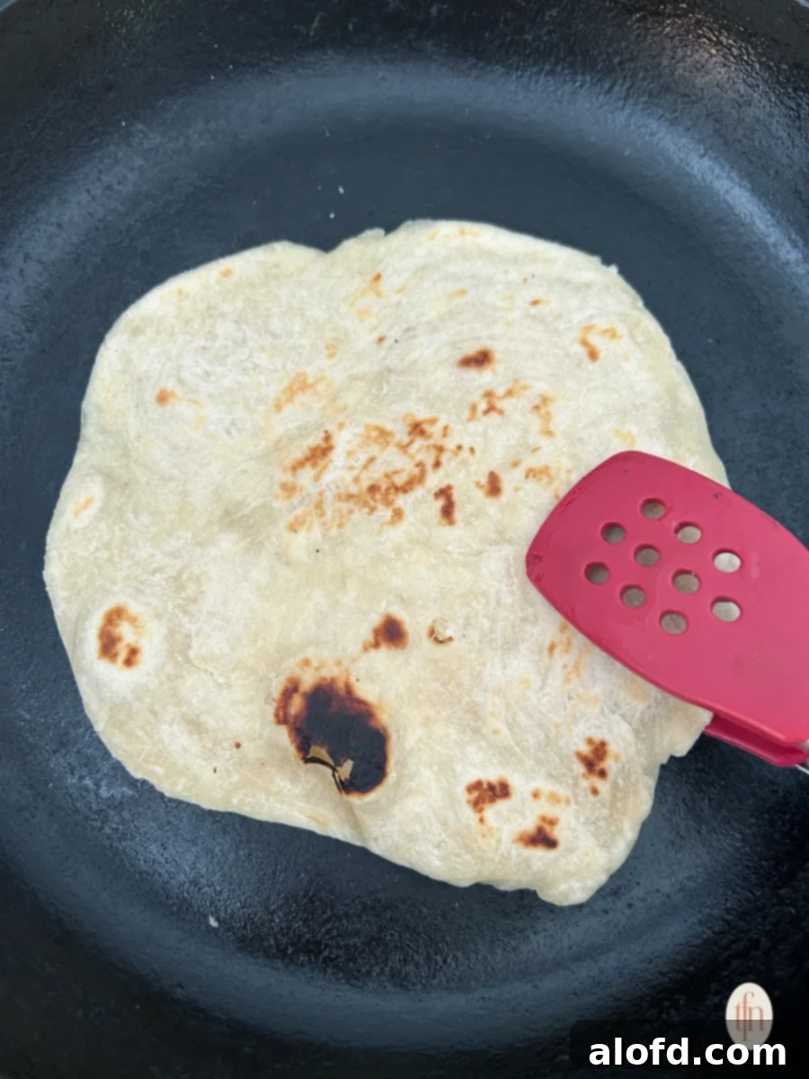 Artisan Sourdough Flatbread 8 Cooking sourdough flatbread on a hot cast iron skillet, with bubbles forming.