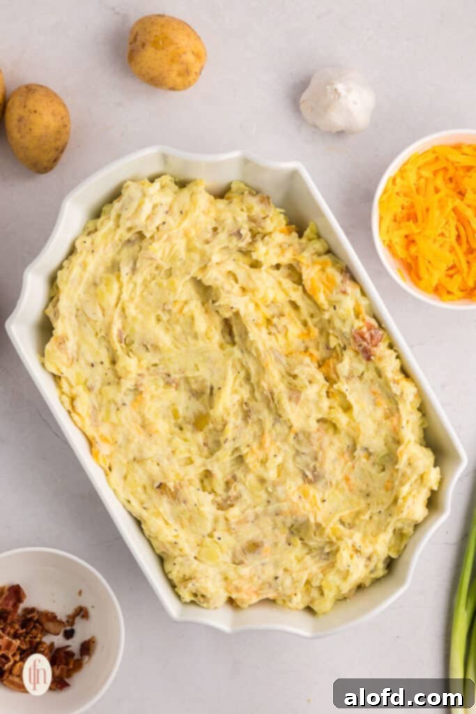 The mashed potato mixture smoothed into a white casserole dish, ready for its topping.
