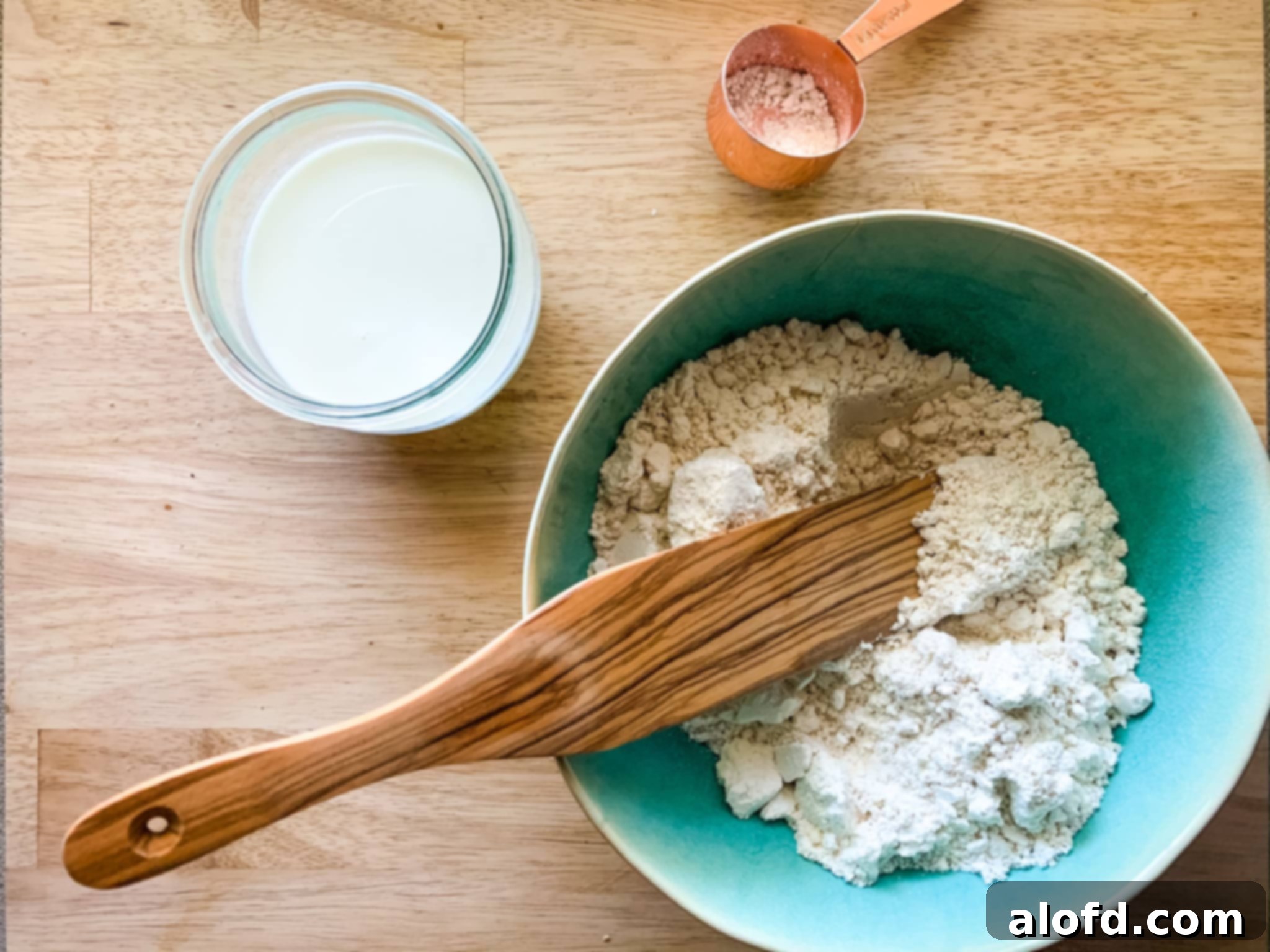 Easy Homemade Bisquick Strawberry Cobbler 6 Bisquick biscuit mix in a green bowl with ladle and a glass of milk, ready for the cobbler topping.