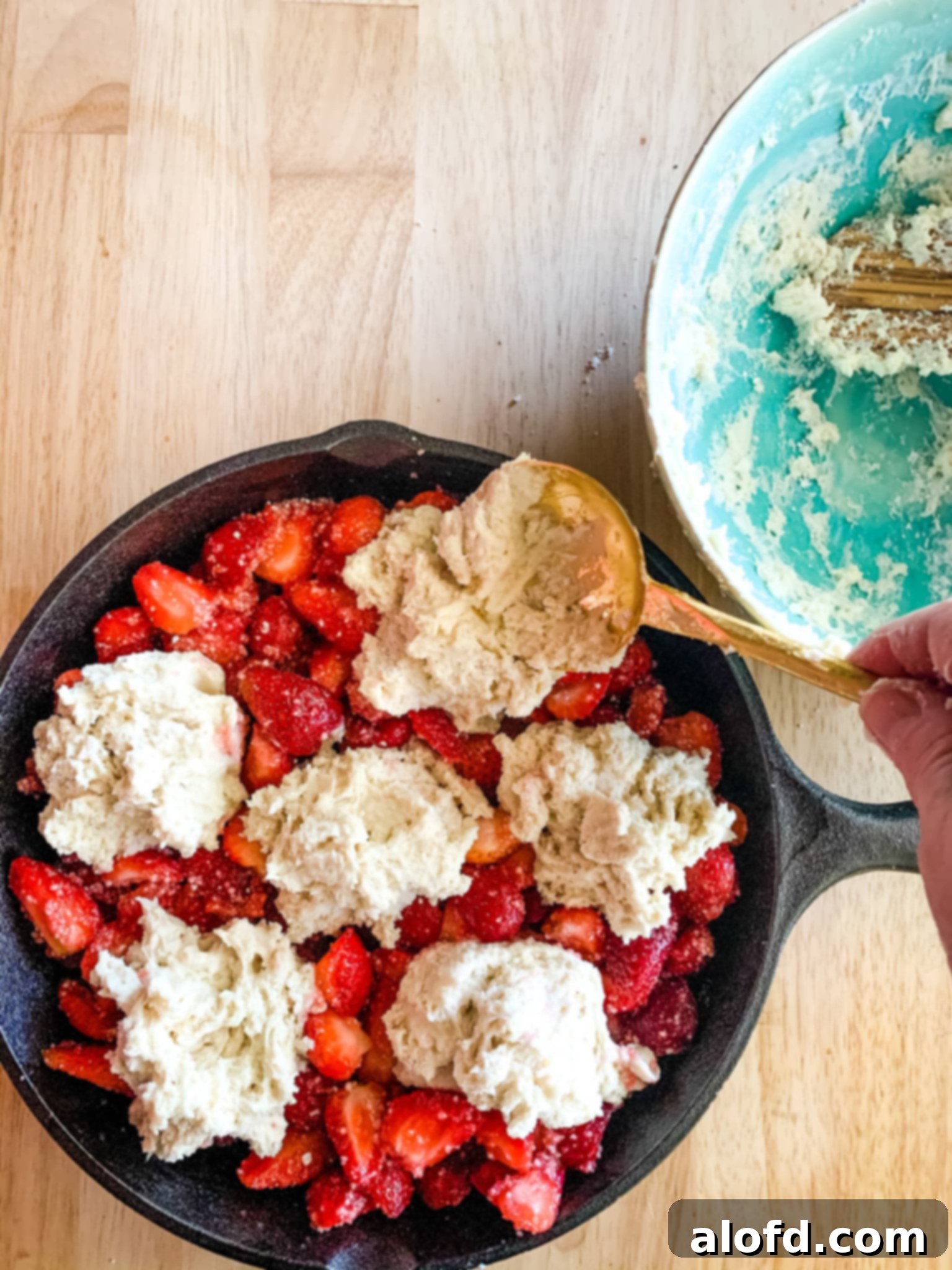 Easy Homemade Bisquick Strawberry Cobbler 7 Bisquick Strawberry Cobbler baking in a Cast Iron Skillet, showing golden biscuits and bubbly fruit.