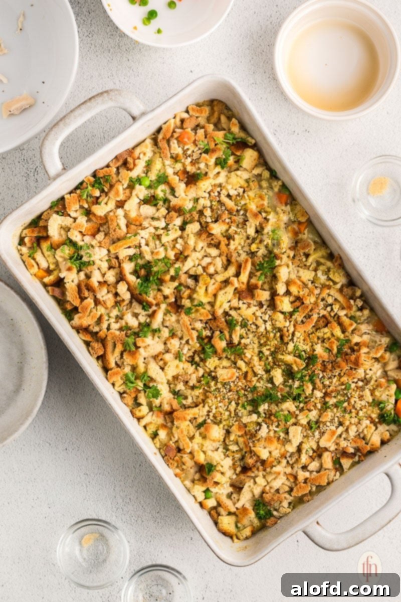 A freshly baked chicken Stove Top stuffing casserole in a white baking dish, golden and bubbly, ready to be served.