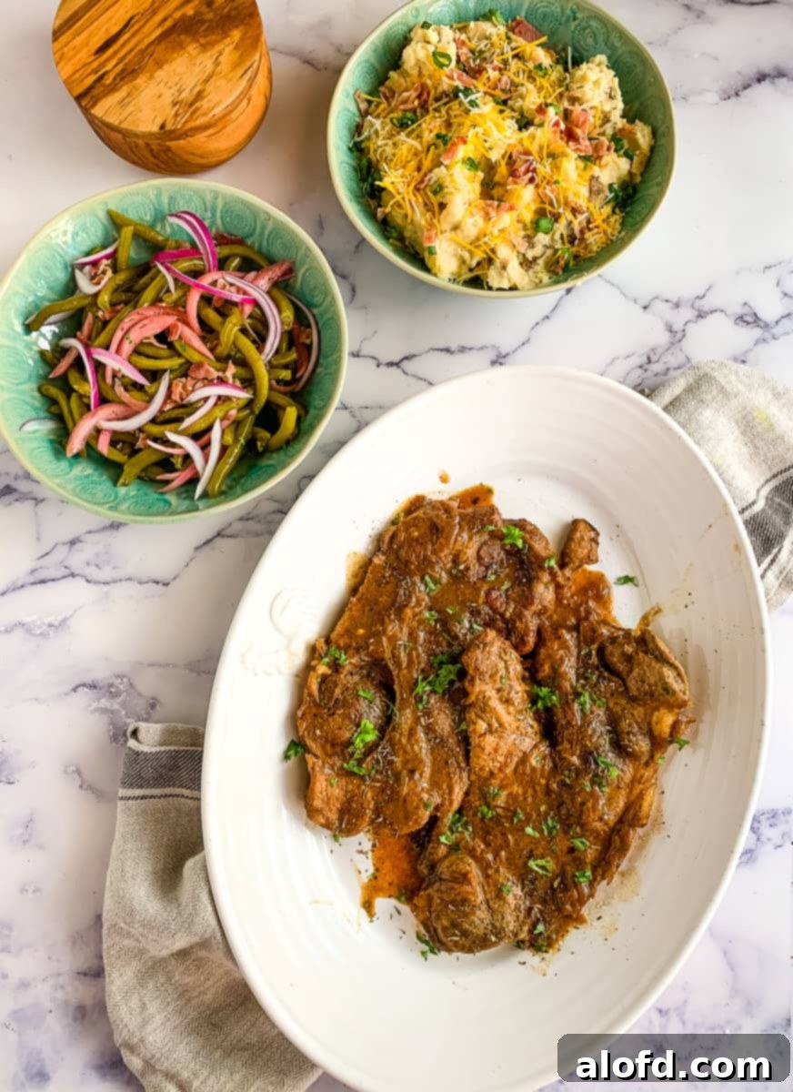 Instant Pot Pork Chops served with loaded potatoes and green beans.