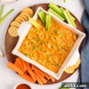 Creamy Dairy-Free Buffalo Chicken Dip 15 A serving of buffalo dip on a platter with crackers and vegetables.