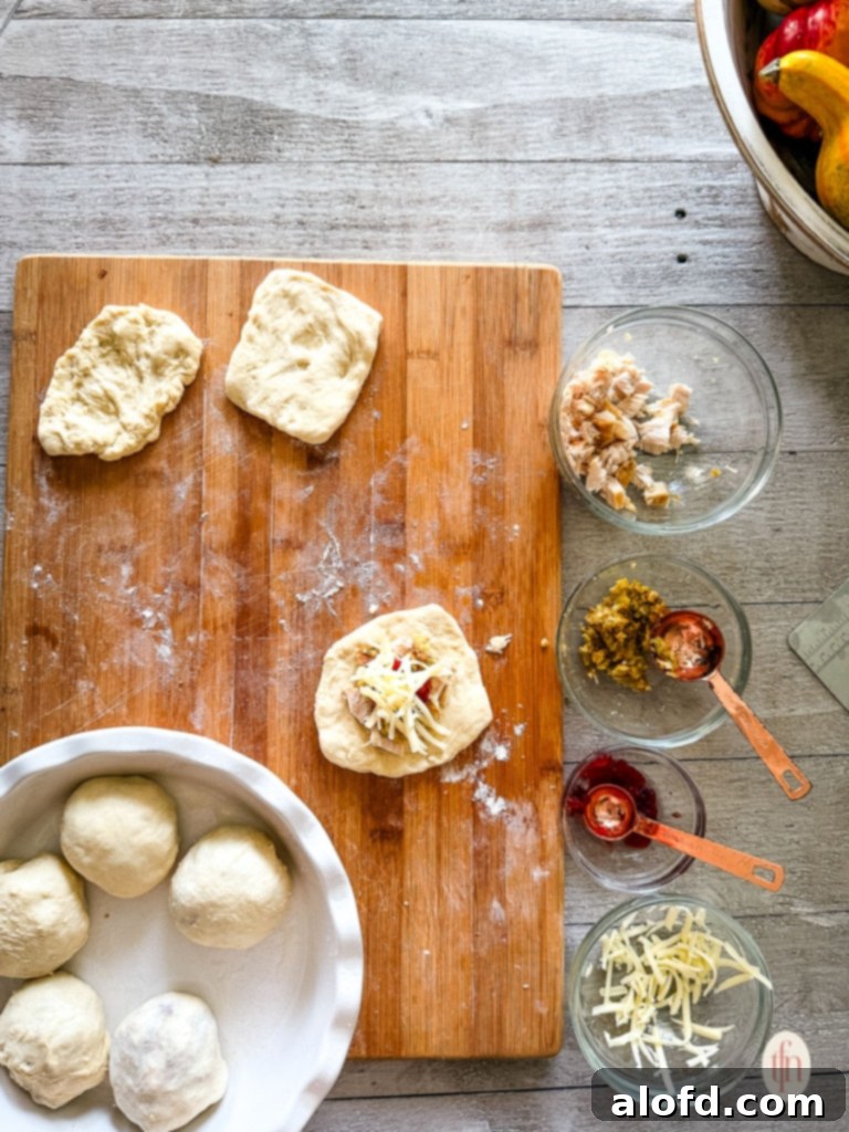 Stuffing the rolls with turkey, stuffing, cranberry sauce, and shredded cheese.