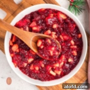 Jello mixture in a white bowl with wooden spoon.