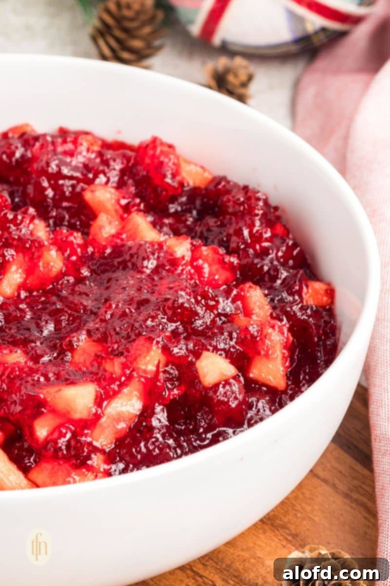 A large bowl filled with vibrant red jello mixture, glistening and ready for the next step of adding fruit.