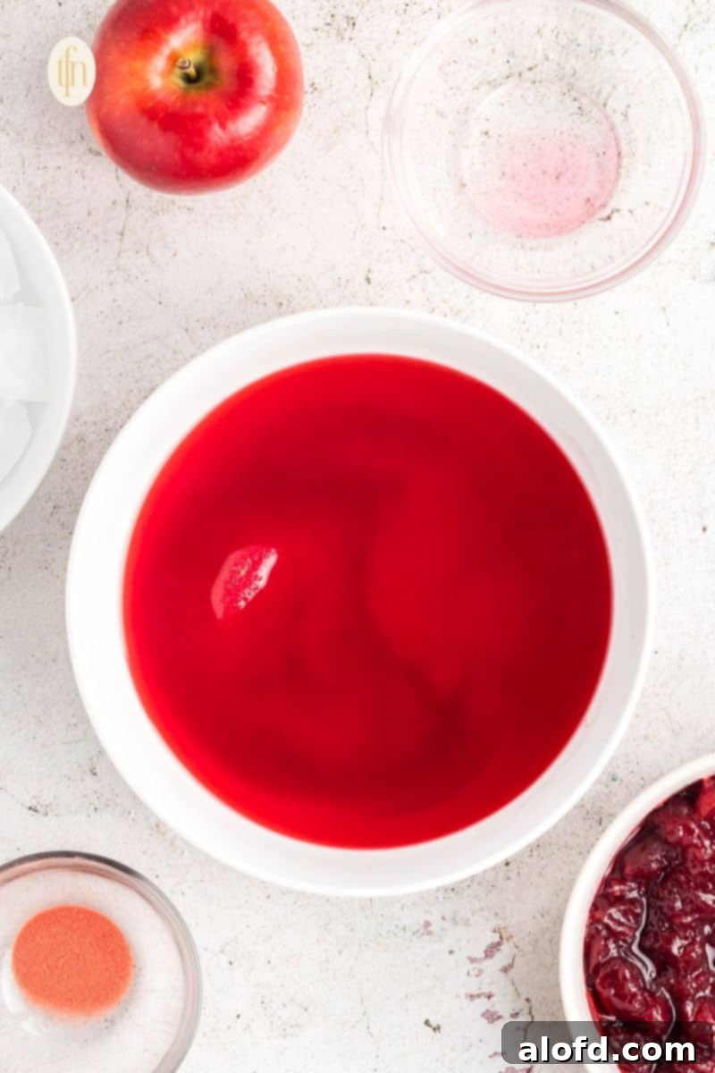 A bowl of thickened red liquid, showing the gelatin after the ice has been removed and it's starting to firm up.