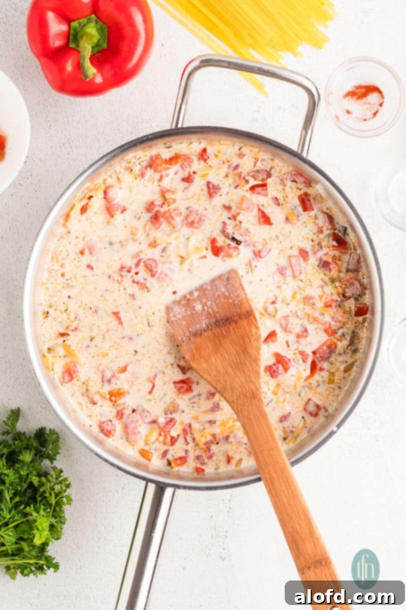 Spicy Rotel Chicken Spaghetti Casserole 10 Creamy sauce simmering in a pan before adding cream cheese.
