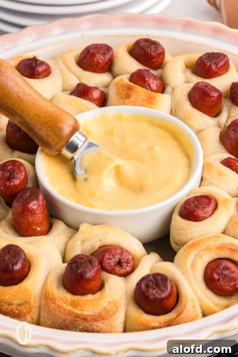 Loaded Pigs in a Blanket Bake 14 A bowl of sauce in the middle of baked pigs in a blanket.