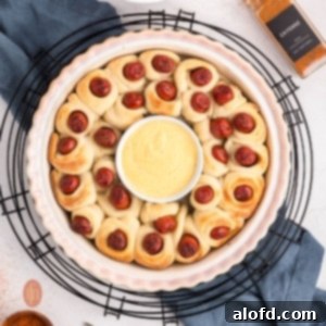 Loaded Pigs in a Blanket Bake 16 A bowl of sauce in the middle of baked pigs in a blanket.