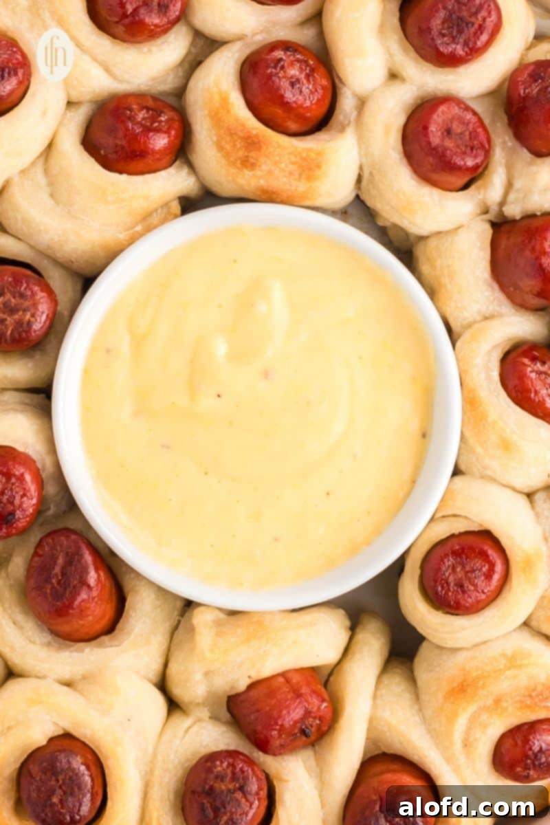 Loaded Pigs in a Blanket Bake 7 A bowl of sauce in the middle of baked pigs in a blanket.