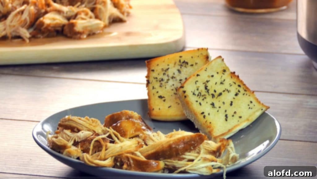 Effortless Instant Pot: 5-Ingredient Meals 7 Mouthwatering Pulled BBQ Chicken served on a plate with toasted garlic bread, a simple Instant Pot meal.