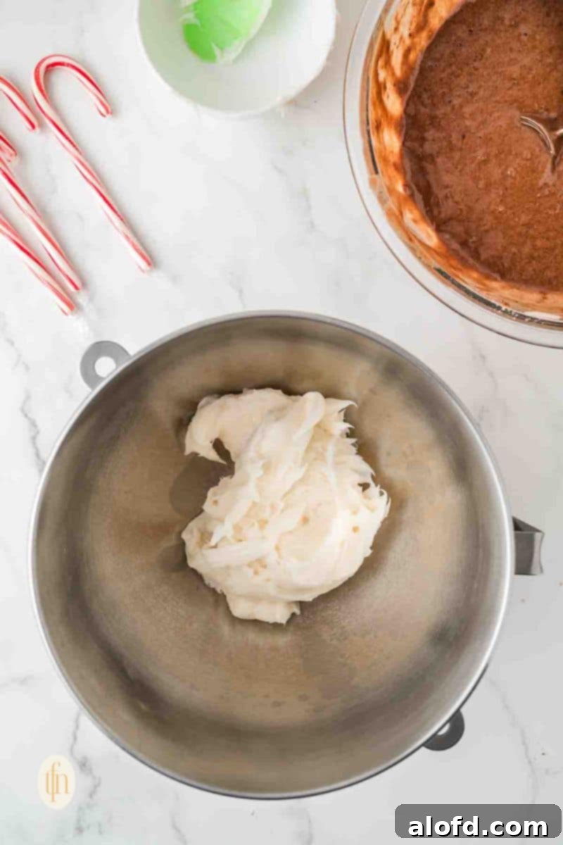 Decadent Peppermint Chocolate Cupcakes 11 Heavy whipping cream being poured into a stainless steel bowl.