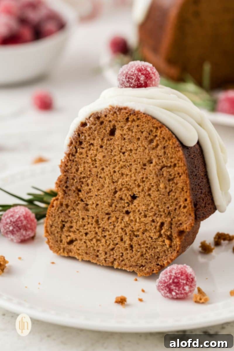 Spiced Molasses Bundt Cake 13 A close-up view of a slice of moist gingerbread bundt cake, revealing its tender crumb and the elegant sheen of its vanilla glaze.