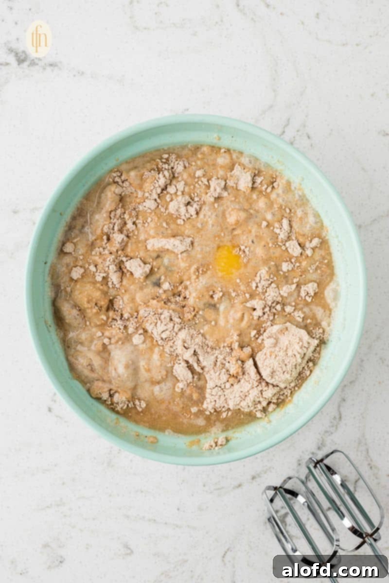 Spiced Molasses Bundt Cake 8 Further mixed cake batter, displaying a perfectly smooth and well-incorporated consistency in the green bowl, ready for baking.
