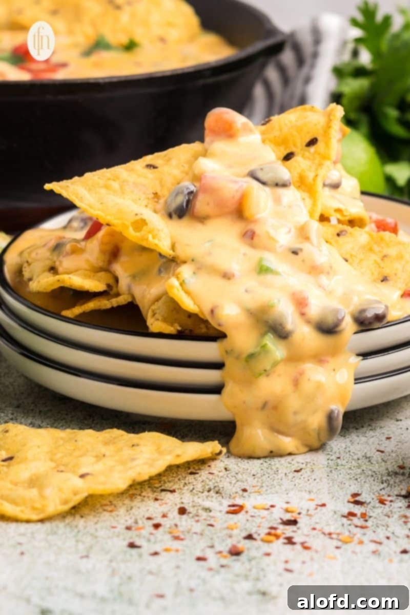 Three stacks of plate with nachos on top.