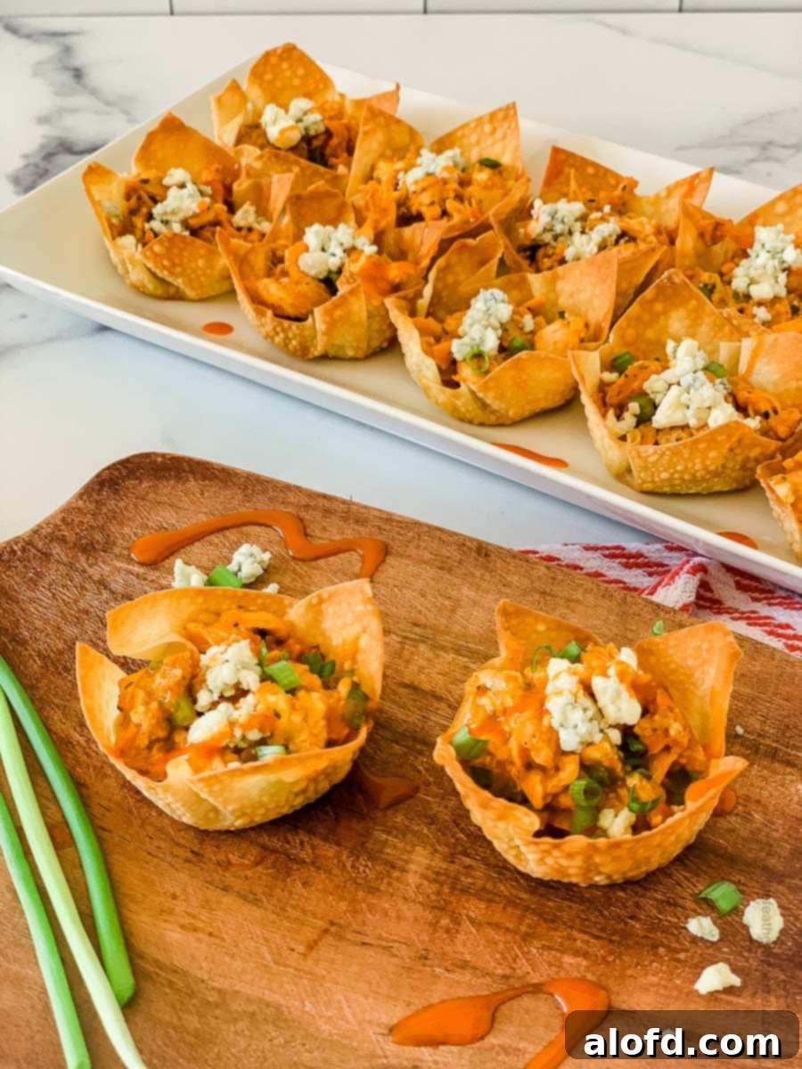 buffalo chicken wonton cups placed in a wooden serving tray and white serving plate.