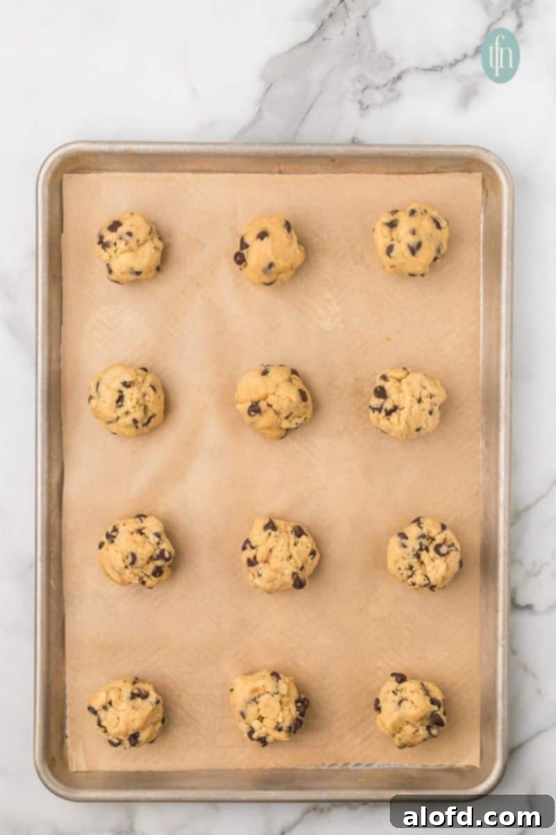 Artisan Sourdough Chocolate Chip Cookies 17 Cookie dough on a baking sheet with parchment paper.