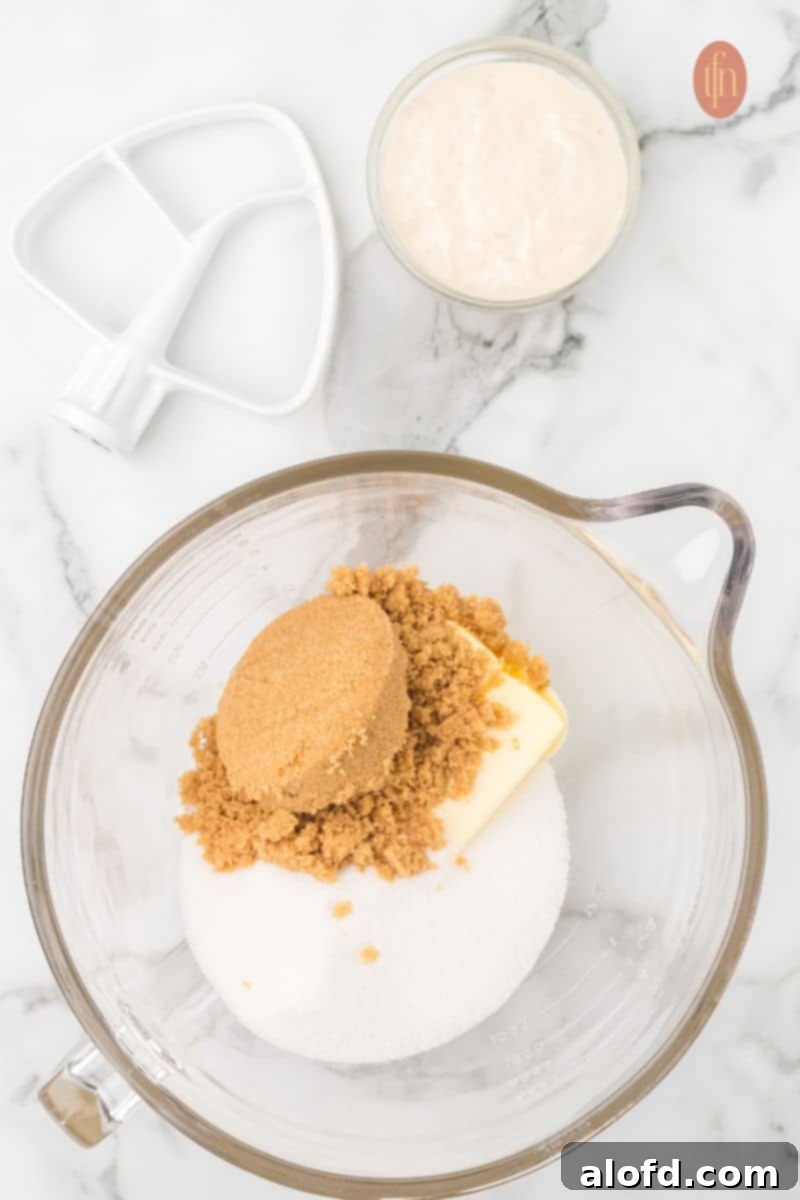 Artisan Sourdough Chocolate Chip Cookies 6 A bowl of sugar and butter with a small bowl of starter and paddle.