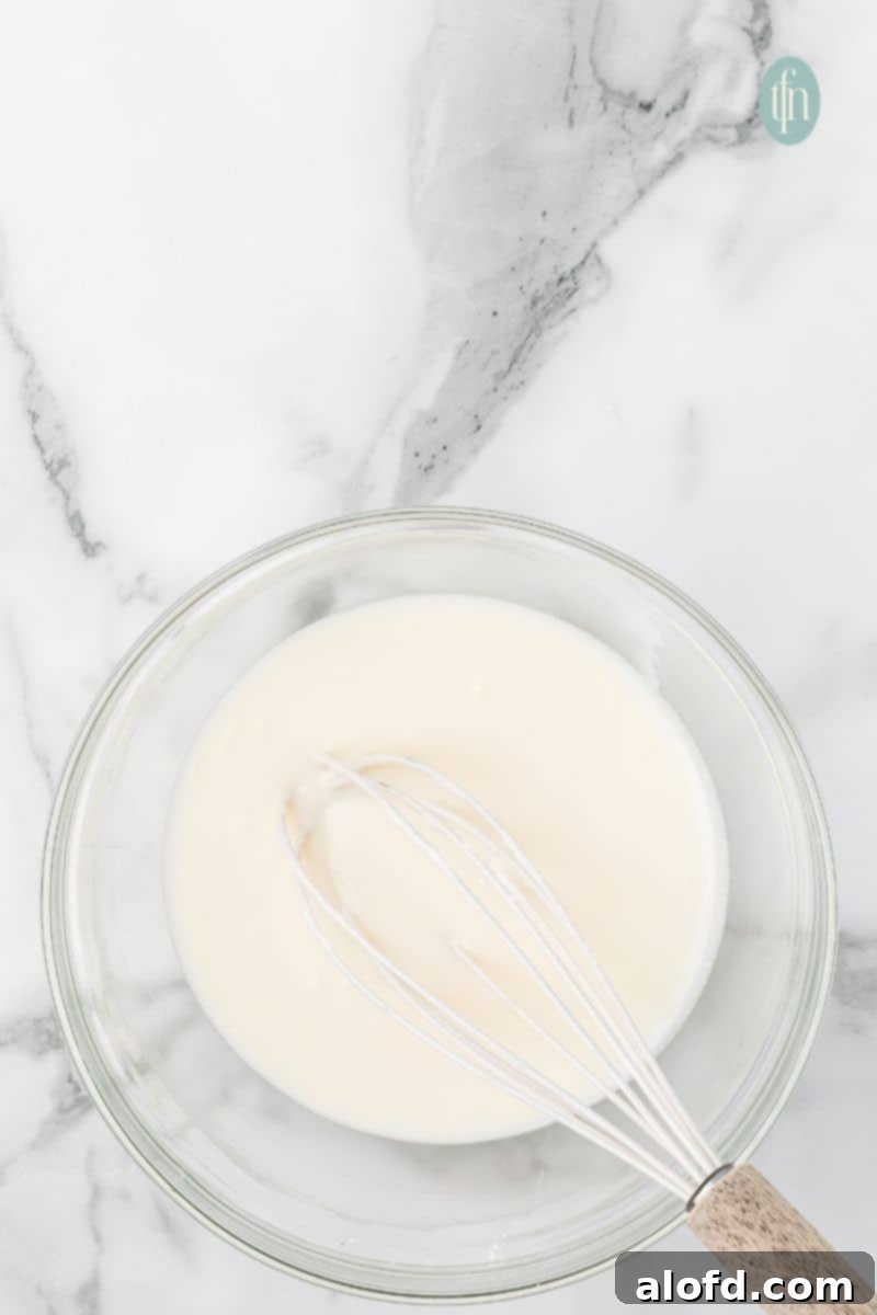 A bowl of glaze with whisk.