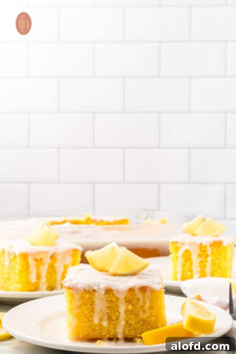 Three slices of cake with white glaze and slice of lemon on top.