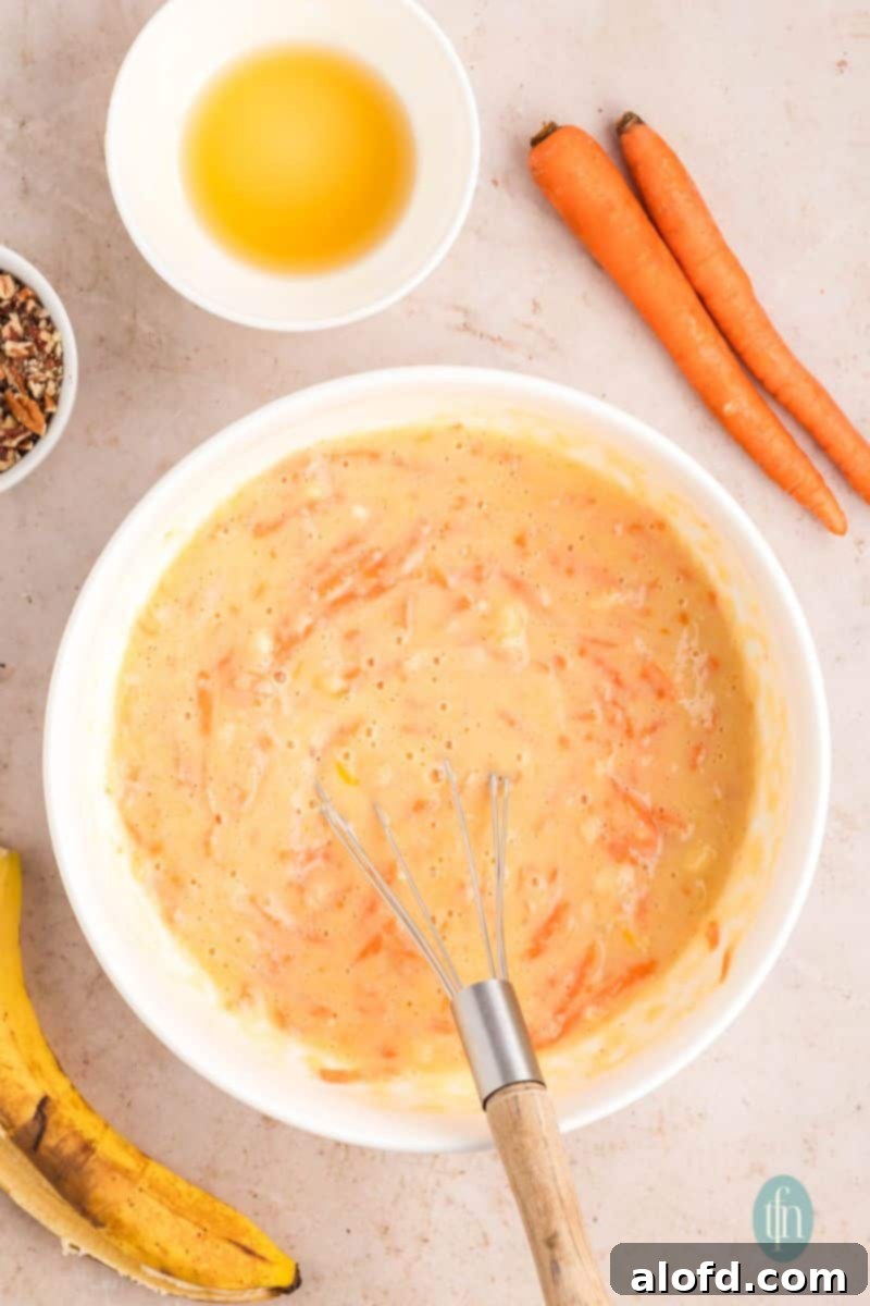 Farmhouse Carrot Cake Loaf 14 A bowl of batter mixture with whisk.