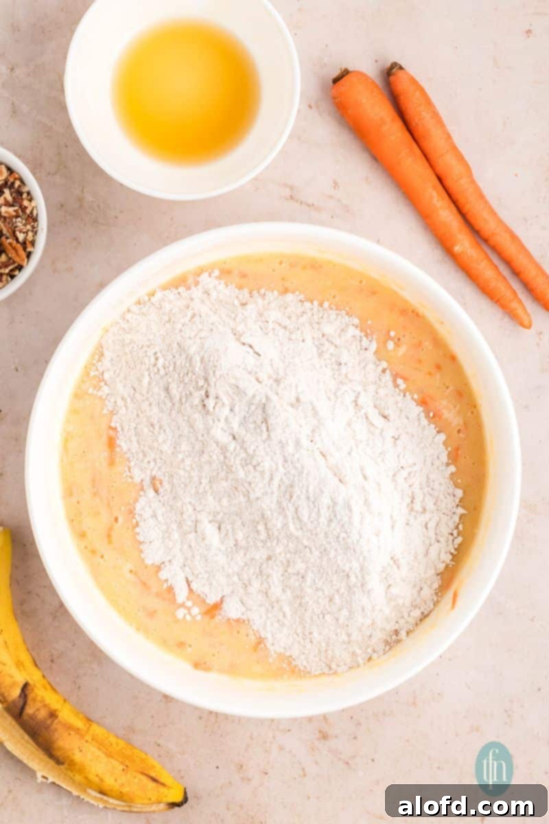 Farmhouse Carrot Cake Loaf 15 A bowl of batter with flour mixture.