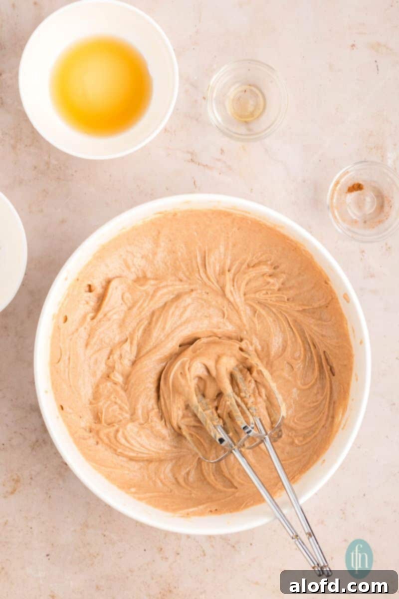 Farmhouse Carrot Cake Loaf 20 Whipped frosting in a bowl with whisk.