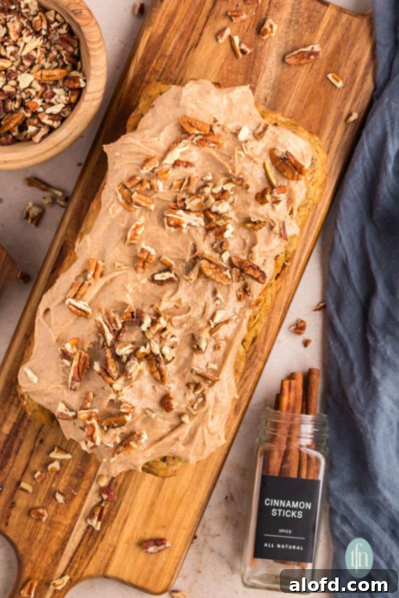 Farmhouse Carrot Cake Loaf 24 loaf with frosting topped with nuts.