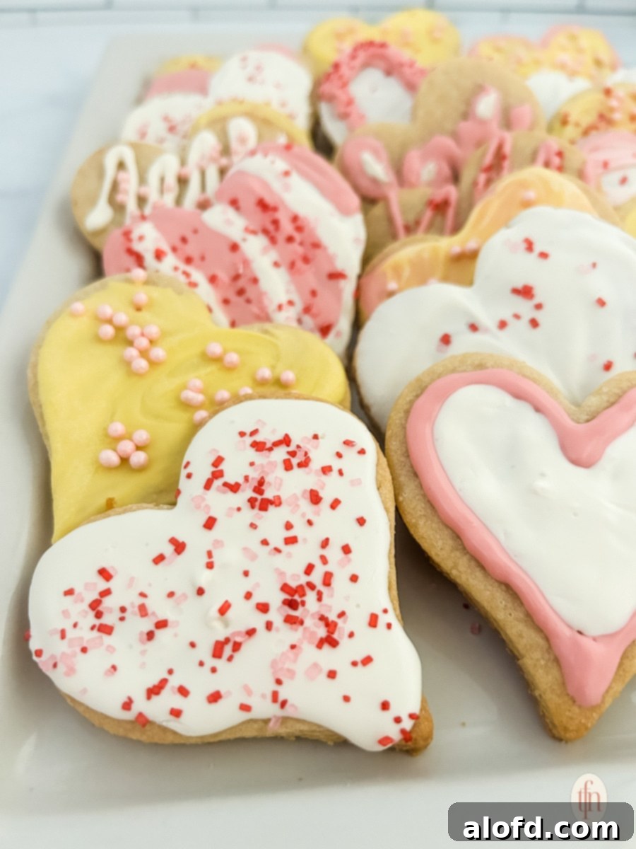 Delicate heart sugar cookies with pink frosting arranged on a pristine white plate, ready for gifting or enjoying.
